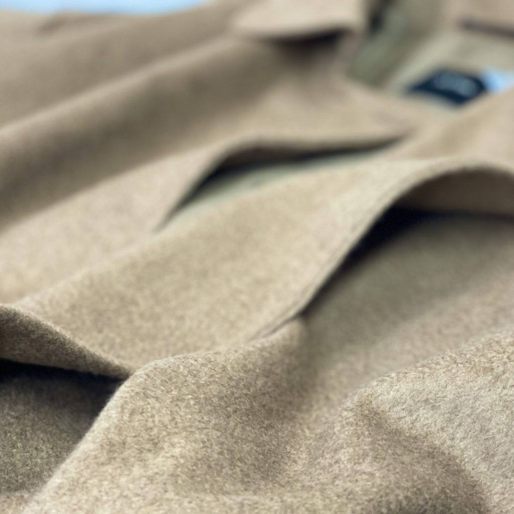 お買取したエイトンのピュアキャメルローデンコートの光沢感を表現した写真です。